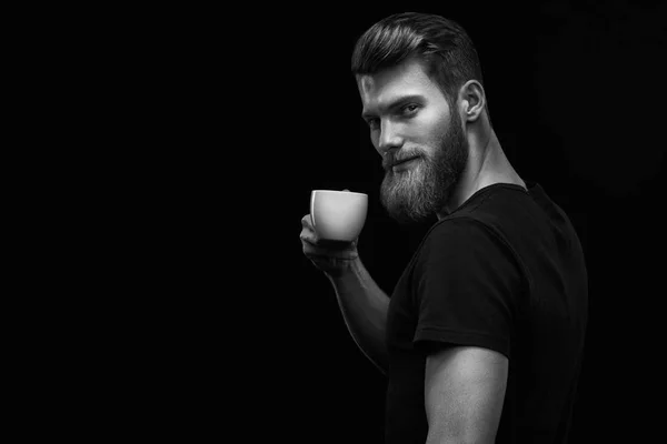 Sonriente hipster barbudo hombre sosteniendo taza de café —  Fotos de Stock