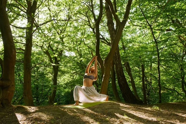 Young asian woman doing yoga in the forest