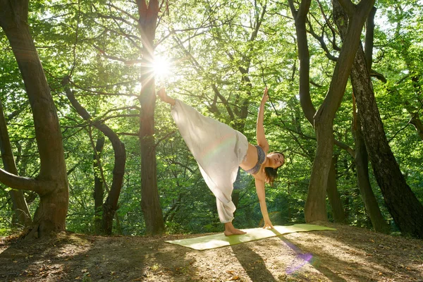 Young asian woman doing yoga in the forest