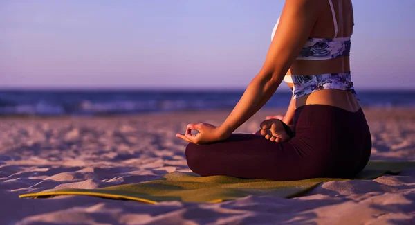 Молодая женщина медитирует, практикуя йогу у моря — стоковое фото