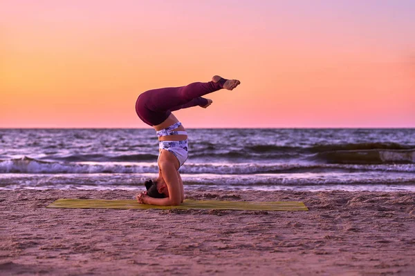 Young asian woman doing yoga by the sea at sunset — Stock Photo, Image