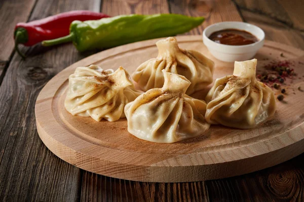 Caucasian dumplings Khinkali with meat and red pepper, on wooden cutting board A traditional dish of Georgian cuisine The concept of diet and healthy eating
