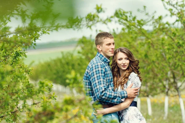 Attrayant jeune couple heureux sur un jardin de printemps — Photo