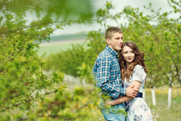 Attrayant jeune couple heureux sur un jardin de printemps — Photo