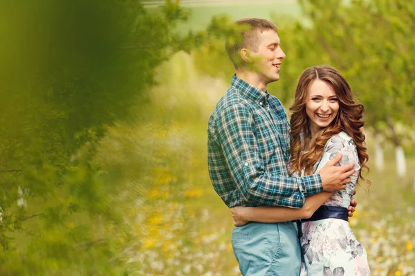 Attrayant jeune couple heureux sur un jardin de printemps — Photo