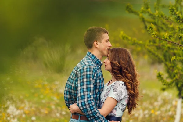 Attrayant jeune couple heureux sur un jardin de printemps — Photo