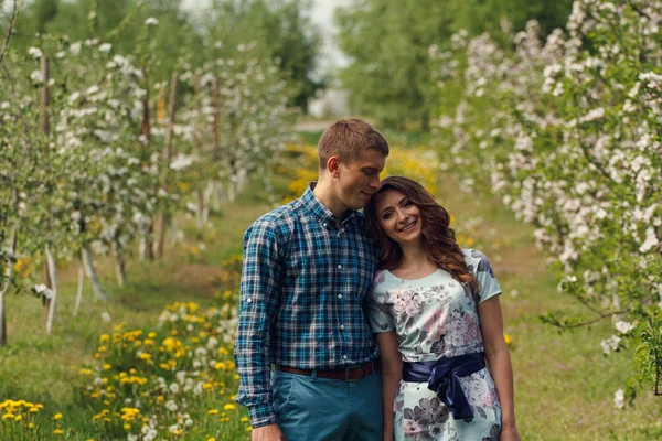 Attrayant jeune couple heureux sur un jardin de printemps — Photo