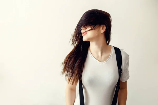En ung kvinna med långt mörkt hår i en vit jacka — Stockfoto