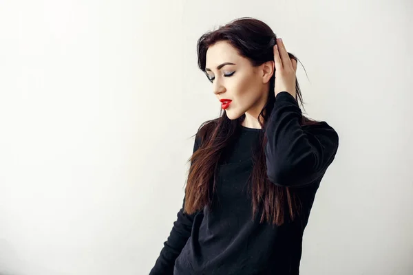 Mooie sexy meid met lang donker haar in een zwarte jas — Stockfoto