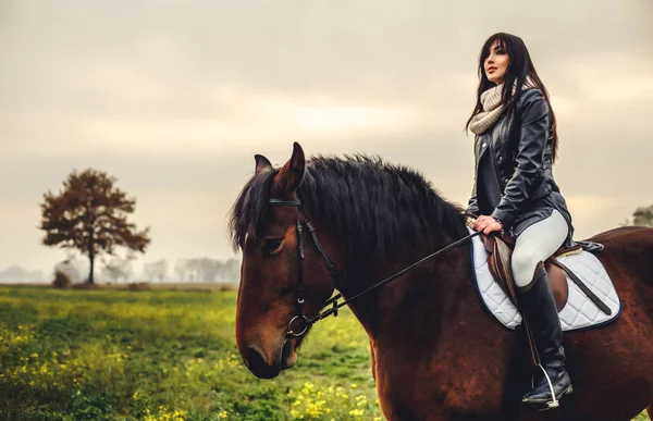 Menina bonita montando um cavalo — Fotografia de Stock