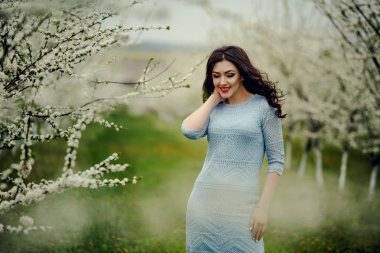 Bahar kız. Çiçek çelenk başında güzel modeliyle. Mavi gözleri ve uzun parlak saçlar ile romantik şehvetli esmer Bayan portresi kapatın. Dantelli elbise uzaktan bakarak Prenses rüya.