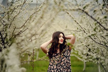 Bahar kız. Çiçek çelenk başında güzel modeliyle. Mavi gözleri ve uzun parlak saçlar ile romantik şehvetli esmer Bayan portresi kapatın. Dantelli elbise uzaktan bakarak Prenses rüya.