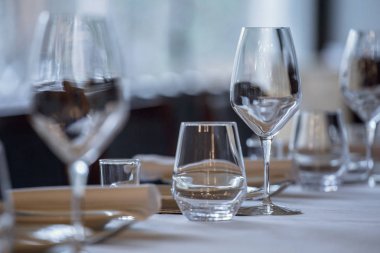 Restoranda boş gözlük. Çatal bıçak takımı bir restoran sofra, bıçak, çatal, kaşık, iç tablo. Restoranda yemek masası üzerinde şarap kadehi tarih seçici yumuşak odak.