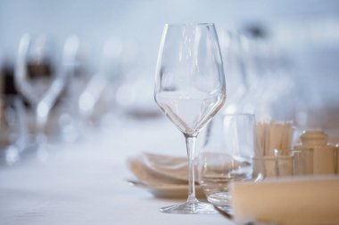 Restoranda boş gözlük. Çatal bıçak takımı bir restoran sofra, bıçak, çatal, kaşık, iç tablo. Restoranda yemek masası üzerinde şarap kadehi tarih seçici yumuşak odak.