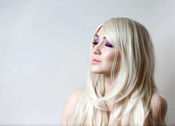 Femme modèle de mode dans la lumière, portrait de beau modèle avec maquillage fluorescent, Art design coloré maquillage. Portrait de belle jeune femme avec de longs cheveux bruns colorés et un maquillage lumineux . — Photo