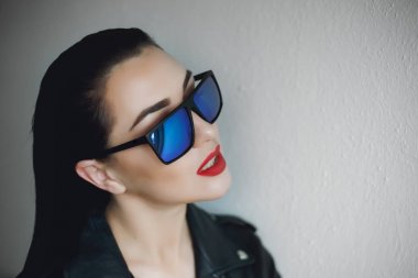  Güneş gözlüğü ve deri ceket giyen güzel bir punk kadın modeli..