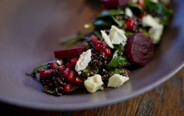 Taze tatlı bebek ıspanak, lahana marul, fındık, beyaz peynir ve tost ile sağlıklı pancar salatası erimiş. Pancar, closeup ile taze salata. Kase salata için rustik ahşap masa üzerinde doğranmış kırmızı pancar (pancar). 