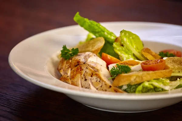 Salade de poulet aux légumes-feuilles, blettes, œufs, bulgur et tomates cerises. Salade de poulet César. Salade César avec poulet grillé dans l'assiette. Poitrines de poulet grillées et salade fraîche dans une assiette . — Photo
