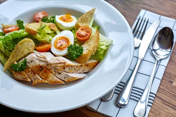 Tavuk salatası yaprak sebze, pazı, yumurta, bulgur ve kiraz domates. Tavuklu Sezar salata. Sezar salatası ile plaka üzerinde ızgara tavuk. Izgara tavuk göğsü ve plaka taze salata.