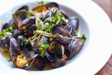 Taze istiridye baharatlı sos sebze salatası ile tepesinde. Bir plaka üzerinde taze istiridye.