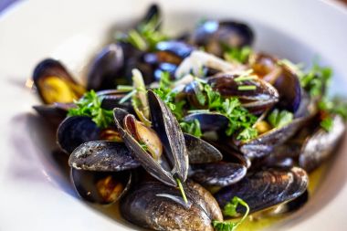 Taze istiridye baharatlı sos sebze salatası ile tepesinde. Bir plaka üzerinde taze istiridye.