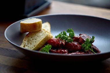 sıcak salata tavuk karaciğer ve üzüm beyaz tabakta. Türkiye'de karaciğer üzerinden sıcak salata. Sıcak salata tavuk karaciğer frambuaz sos ile.