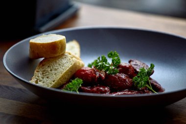 sıcak salata tavuk karaciğer ve üzüm beyaz tabakta. Türkiye'de karaciğer üzerinden sıcak salata. Sıcak salata tavuk karaciğer frambuaz sos ile.