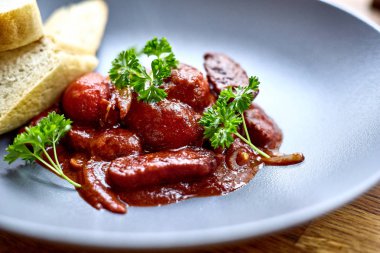 sıcak salata tavuk karaciğer ve üzüm beyaz tabakta. Türkiye'de karaciğer üzerinden sıcak salata. Sıcak salata tavuk karaciğer frambuaz sos ile.