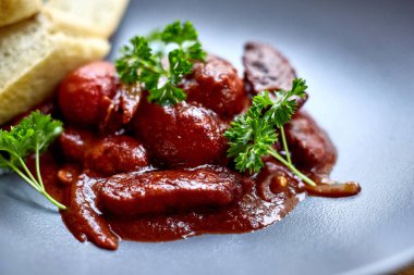 sıcak salata tavuk karaciğer ve üzüm beyaz tabakta. Türkiye'de karaciğer üzerinden sıcak salata. Sıcak salata tavuk karaciğer frambuaz sos ile.