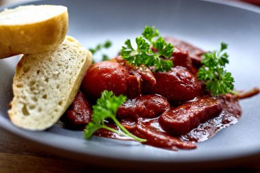 sıcak salata tavuk karaciğer ve üzüm beyaz tabakta. Türkiye'de karaciğer üzerinden sıcak salata. Sıcak salata tavuk karaciğer frambuaz sos ile.