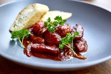 sıcak salata tavuk karaciğer ve üzüm beyaz tabakta. Türkiye'de karaciğer üzerinden sıcak salata. Sıcak salata tavuk karaciğer frambuaz sos ile.