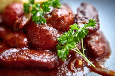 sıcak salata tavuk karaciğer ve üzüm beyaz tabakta. Türkiye'de karaciğer üzerinden sıcak salata. Sıcak salata tavuk karaciğer frambuaz sos ile.