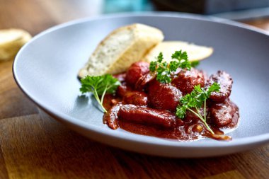 sıcak salata tavuk karaciğer ve üzüm beyaz tabakta. Türkiye'de karaciğer üzerinden sıcak salata. Sıcak salata tavuk karaciğer frambuaz sos ile.