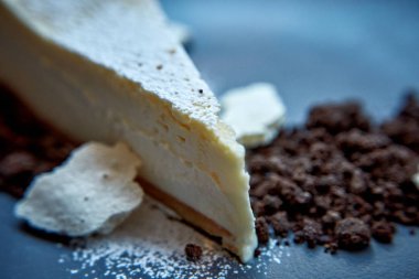 Dilimlenmiş New York Cheesecake beyaz tabakta ahşap arka planda