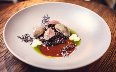 sıcak salata tavuk karaciğer ve üzüm beyaz tabakta. Türkiye'de karaciğer üzerinden sıcak salata. Sıcak salata tavuk karaciğer frambuaz sos ile.