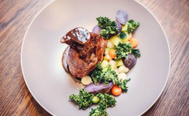 Domuz knuckle patates ve salata, üstten görünüm ile bir tavada kavrulmuş. Kırmızı şarap soslu sebzeli kuzu eklemleri.