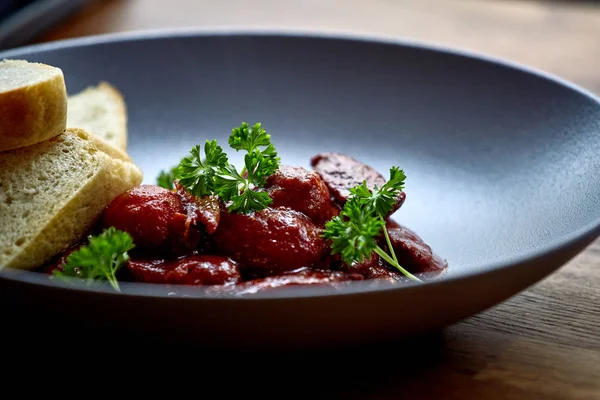 sıcak salata tavuk karaciğer ve üzüm beyaz tabakta. Türkiye'de karaciğer üzerinden sıcak salata. Sıcak salata tavuk karaciğer frambuaz sos ile.