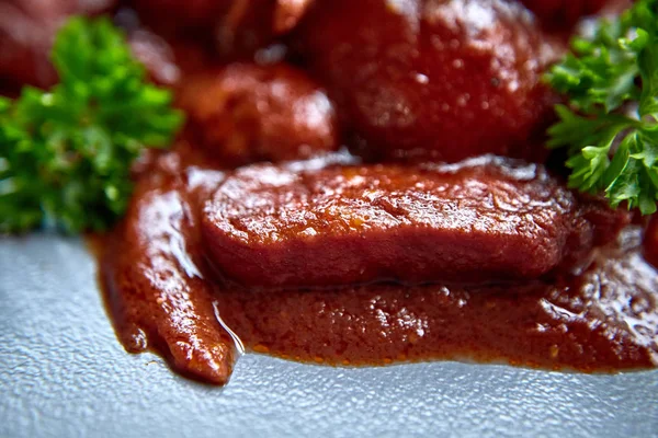 sıcak salata tavuk karaciğer ve üzüm beyaz tabakta. Türkiye'de karaciğer üzerinden sıcak salata. Sıcak salata tavuk karaciğer frambuaz sos ile.