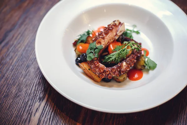 The process of eating the delicious grilled octopus. jukkumi bokkeum is korea traditional webfoot octopus with vegetable stir fry. — Stock Photo, Image