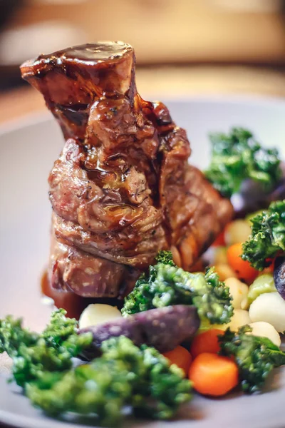 Knuckle babi panggang dalam wajan dengan kentang dan salad, pemandangan atas. Domba Knuckles with Vegetable in Red Wine Sauce . — Stok Foto