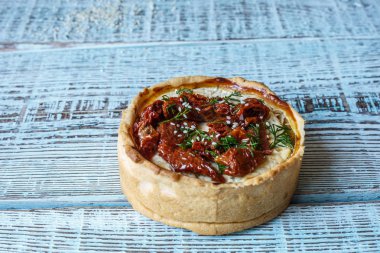 Tablo, bir yatay üstten görünüm, rustik tarzı Avustralya etli börek. Ahşap masa portre üzerinde ev yapımı Avustralya etli börek. Lezzetli bir plaka üzerinde et pastası kesti. Amerikan Tavuklu paçanga böreği masaya pişirme çanağı içinde.