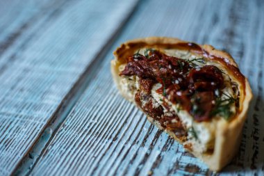 Avustralya et pasta tablo ve soğan ve avokado üzerinde yatay bir üstten görünüm, rustik tarzı. Ahşap masa portre üzerinde ev yapımı Avustralya etli börek. Lezzetli bir plaka üzerinde et pastası kesti. Amerikan Tavuklu paçanga böreği masaya pişirme çanağı içinde.