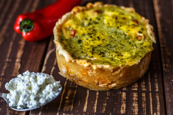 Australian meat pie on the table and red pepper chili a horizontal top view, rustic style. Homemade australian meat pie on the wooden table closeup. Delicious cut meat pie on a plate. American Chicken pot pie in the baking dish on the table.