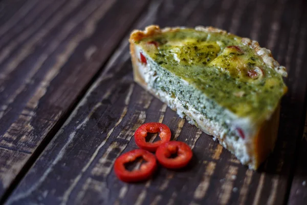 Australian meat pie on the table and red pepper chili a horizontal top view, rustic style. Homemade australian meat pie on the wooden table closeup. Delicious cut meat pie on a plate. American Chicken pot pie in the baking dish on the table. — Stock Photo, Image