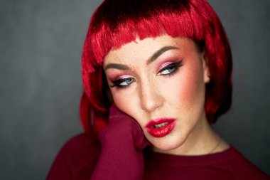 Parlak çilleri ve parlak pembe peruğu olan çekici bir kızın portresi. Tatil ve parti tarzı. Güzellik, makyaj ve kozmetik konsepti.