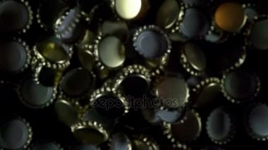 Birçok bira Şişe kapakları. Siyah bir arka plan üzerinde havada yüzen altın bira Şişe kapakları. Ağır çekim 240 fps hızında