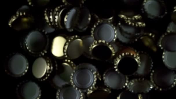 Bouchons de bouteille de bière. Bouchons de bouteille de bière dorée flottant dans l'air sur un fond noir. Mouvement lent à 240 ips 