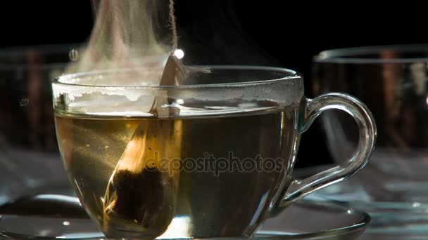 Перерыв Ужин Чайный Пакетик Падает Прозрачную Чашку Горячей Водой Темном — стоковое видео