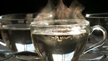 Hazır kahve kaşığı. Şeffaf bir fincan sıcak su ile çözünür kahve granülleri düşüyor. Onlar yavaş yavaş batmakta geçiyoruz. 240 fps hızında çekim.