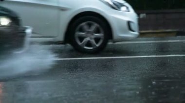 Yağmur acele saat. Araba kamera taşır ve su birikintisi sürmek. Direksiyonu altından su güzel bir akışı yükselir. 240 fps hızında filme